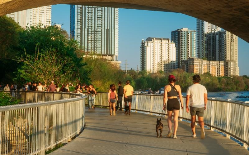 a group of people walking on a bridge over water